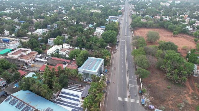 Early morning aerial view of Tanjore&rsquo;s highway bathed in soft light, revealing calm traffic and surrounding rural landscapes.

