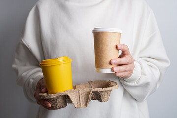 Paper cup with coffee in woman hand. Time to drink coffee. Coffee to go. Enjoy the moment, take a break. Disposable paper cup close-up. Tasty hot drink. Empty space for text, mockup