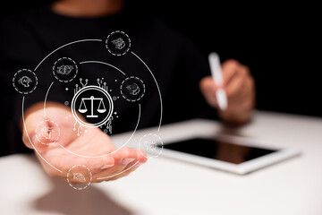 A person holds a digital icon of justice scales surrounded by technology-related symbols, with a...