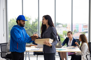 Pizza Delivery Man :  Business Woman receiving Take-out Box pizza from delivery man at home office