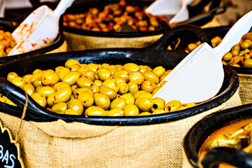 Container with fresh and delicious green olives
