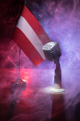 Microphone on a background of a blurry flag of Austria close-up. dark table decoration