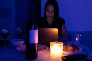 Woman with the laptop in a romantic dinner.
