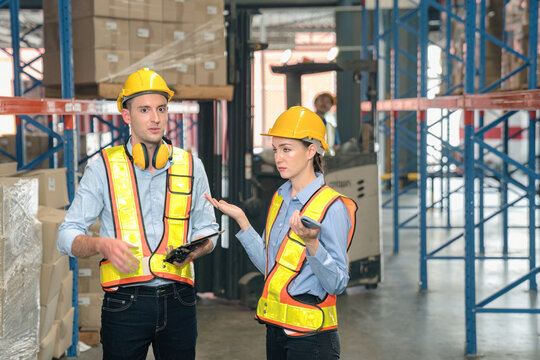 Caucasian man, woman warehouse supervisor discuss and use tablet check package with forklift driver worker load box on shelf, product distribution inventory management,Logistics shipping business plan