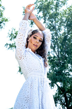 Beautiful teen mixed race girl in summer white dress, outdoor posing and smiling
