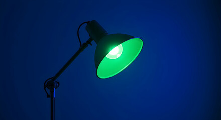Green Desk Lamp Illuminating Dark Blue Background