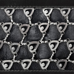 Seamless 4k photo texture material of worn and weathered black leather surface with metal ornate...