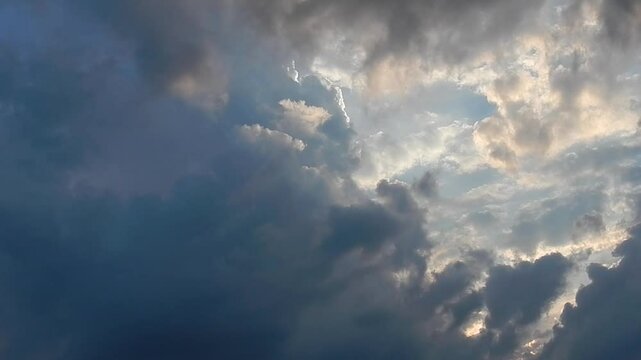 Cloudy evening sky with sunlight, moving different types of clouds at different altitudes with dark rainy and stormy Cumulonimbus calvus - natural weather background. Topics: cloudscape, meteorology