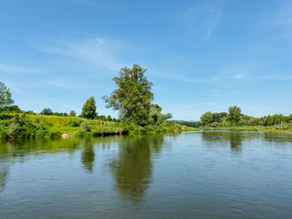 A vast and expansive body of water, beautifully encircled by lush, green trees, creating a...