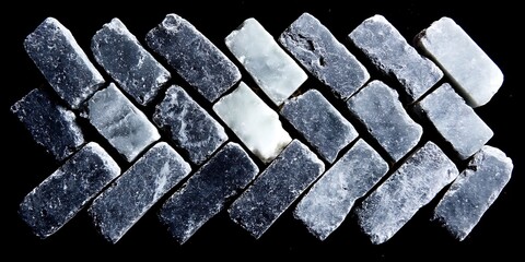 Rectangular shaped stones in different hues of grey arranged as tiles