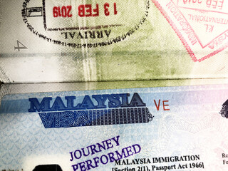 Malaysia Visa is written on a sticker visa in a passport