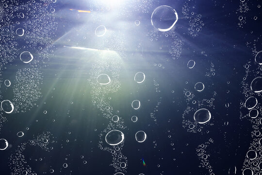 underwater background at depth, air bubbles in the water, aquarium texture of dark water
