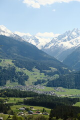 Scenic view of snow-capped mountains and lush green valleys in the Swiss Alps during a sunny day