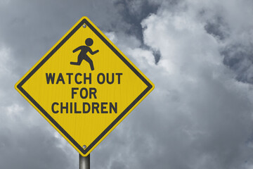 Watch out for Children yellow warning sign with stormy sky