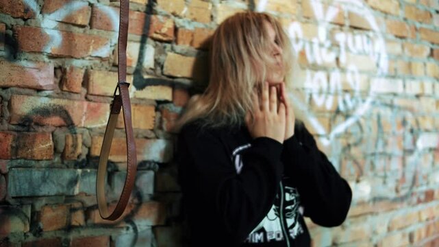 A desperate young girl prepares to commit suicide by hanging. Human hopelessness, suicide by hanging.
