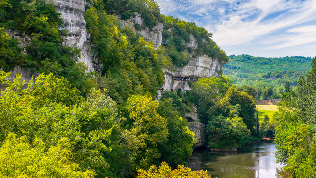 Vezere Valley in Peyzac-le-Moustier, Dordogne, Perigord, France, view of the cliff-side Roque Saint-Christophe cave and canoeing on the Vezere River