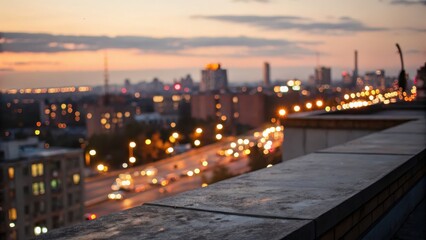 Fototapeta premium Blurry cityscape at dusk with lights and a rooftop edge in the foreground.