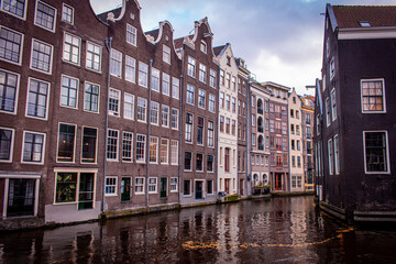 Naklejka premium Amsterdam, Netherlands. A picturesque canal, lined with traditional Dutch buildings featuring tall, narrow facades and large windows.