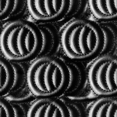 Seamless 4k photo texture material of ornate quilted black leather surface.