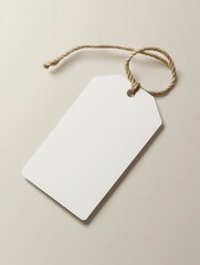 Blank white price tag lying at an angle on a light background with a rope attached in a simple and minimalistic style