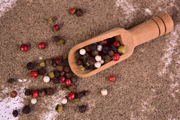 Mix of peppercorns on a background of ground pepper. Flat lay.
