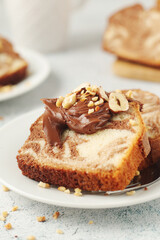 A piece of marble biscuit with chocolate cream and nuts	
