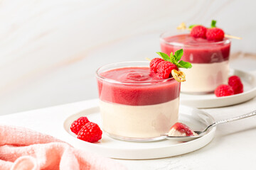Bavarian cream with raspberry coulis, sauce. Set in glass dessert. Egg-based cooked custard and...