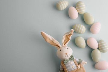 Easter eggs and rabbit toy on pastel background. Top view
