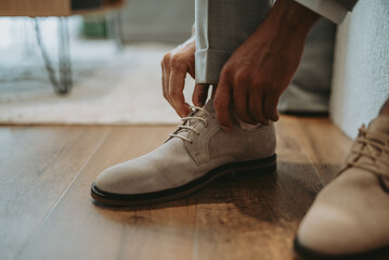 Le marié entrain de mettre ses chaussures avant son mariage