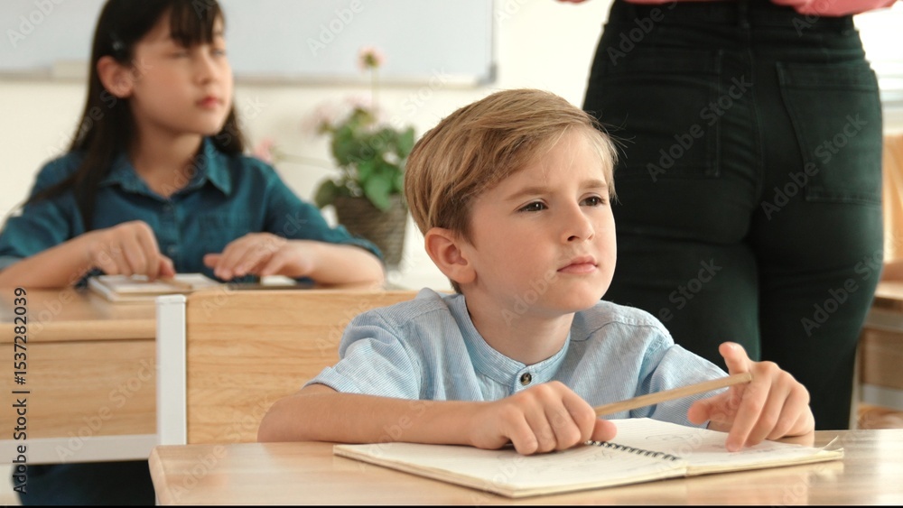 Poster caucasian boy looking at blackboard while diverse skilled student learning at school and taking a no