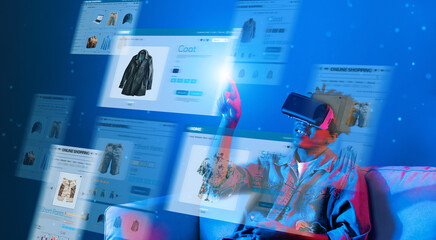 Happy african teenager sitting at sofa while enjoy online shopping while using augmented reality technology. Attractive boy choosing product from shopping list while wearing VR glasses. Ingenuity.