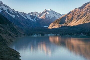 Snow-capped mountains reflected in a lake.
