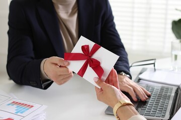 Money bonus. Employee receiving envelope with bow from boss in office, closeup