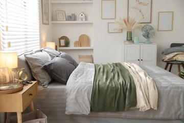 Comfortable bed with soft linens and blankets in room. Home textile