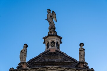 Historic building statues under blue sky.