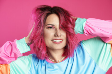 Fototapeta premium Beautiful woman with bright dyed hair on pink background