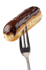 Delicious eclair on a fork isolated, chocolate cream pastry dessert, french patisserie sweet treat