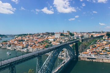 Obraz premium orange rooftops panorama of the old town of porto and duoro river on blue sky day and iron famous eiffel bridge