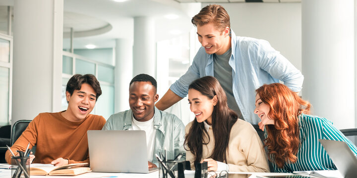 Brainstorm, Teamwork Concept. Smiling mixed race employees or students team watching webinar on laptop together, working with computer, looking at screen, making conference video call, sharing ideas