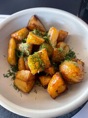 Deliciously roasted potato chunks, perfectly golden-brown and seasoned, generously garnished with fresh dill. A rustic and comforting side dish, ideal for a wholesome meal.