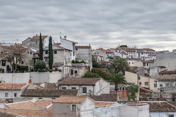 A group of rooftops and a house with the Spanish flag on a corner in the town of Chinchon, province of Madrid, Spain.
