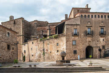 Plaza de San Vicente Ferrer with a stone fountain and the palace and passageway of the Marquises of Mirabel in the background, in Plasencia, Cáceres province, Spain