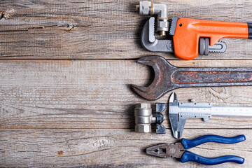 Variety of plumbing tools on wooden background. Top view with copy space.