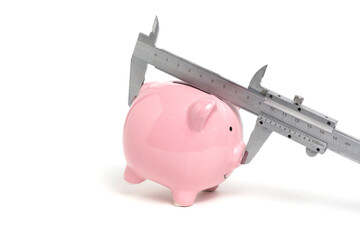 Piggy bank and vernier caliper on white background.