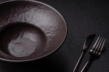 Empty round black plate for food, risotto or pasta. Empty plate on dark background