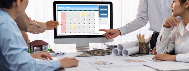 Group of interior architect designer discussing together on blueprint and laptop screen display...