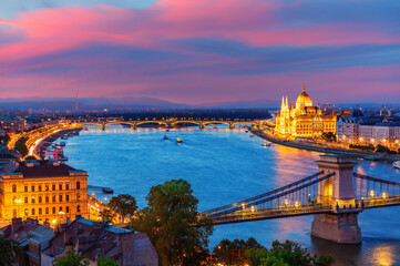 Panoramic evening view of Budapest with Parliament building, Chain Bridge and Danube river at sunset