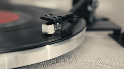 This image features a close-up of a vinyl record player with a stylus, highlighting the intricate details of the turntable as it plays a record, capturing a retro vibe. - Powered by Adobe