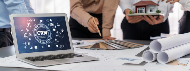 Group of interior architect designer discussing together on blueprint and laptop screen display...