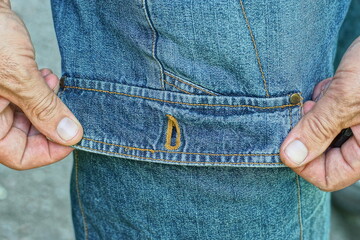 one side with loop pocket in hands with fingers in fashion stylish blue worn men's striped denim shorts on legs day outside